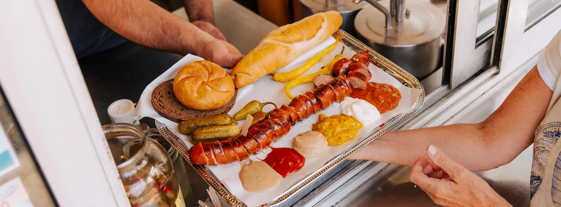 A cut sausage is handed over the counter
