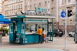 A couple in front of a Viennese sausage stand