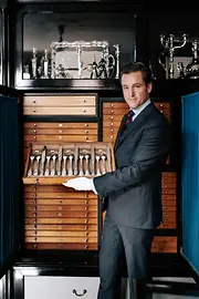 Jean-Paul Vaugoin holding a drawer of silverware