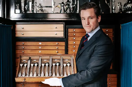 Jean-Paul Vaugoin sosteniendo un cajón con cubiertos de plata.