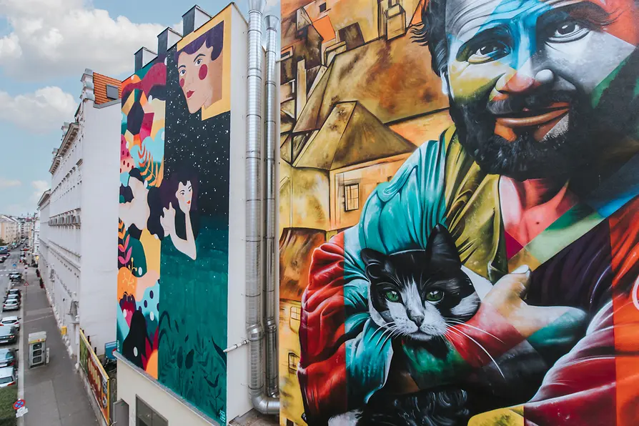 Wall paintings at Wiedner Hauptstrasse 78: Kruella d'Enfer interprets Schiele's \"Female Nude Lying on her Stomach\" and the Brazilian artist Kobra's \"Klimt with Cat\"