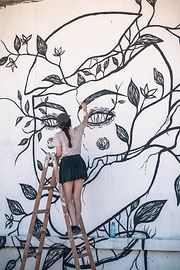 Street-Art: Künstlerin Luna Doz beim Bemalen einer Wand