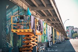 Street-Art: Künstler bemalen die Mauer einer Lagerhalle