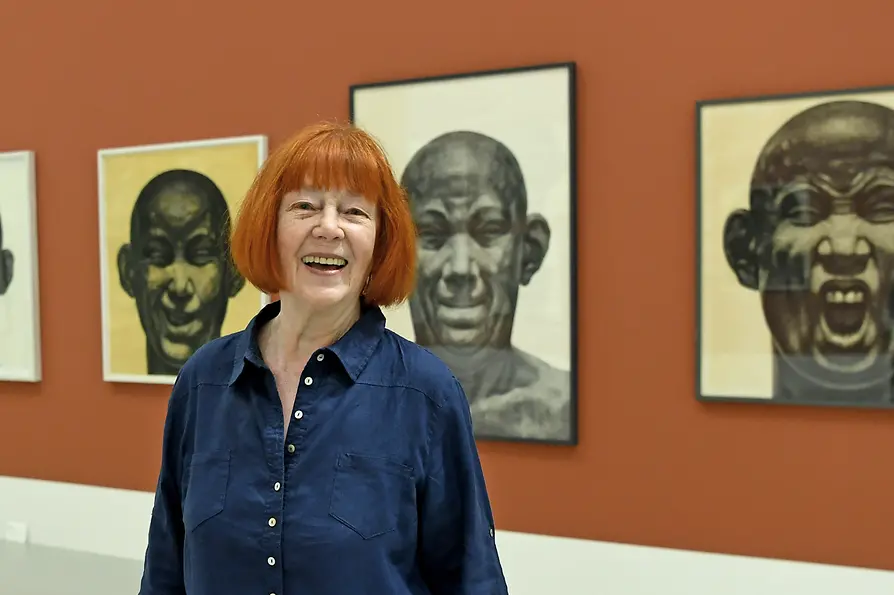 Florentina Pakosta in front of her famous portraits of powerful men