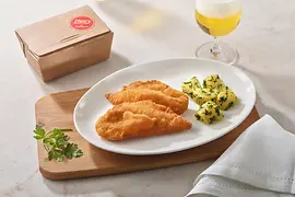 Chicken wiener schnitzel with parsley potatoes arranged on a wooden board with a glass of beer