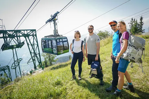 Hikers on the Rax plateau, behind them the Rax cable car