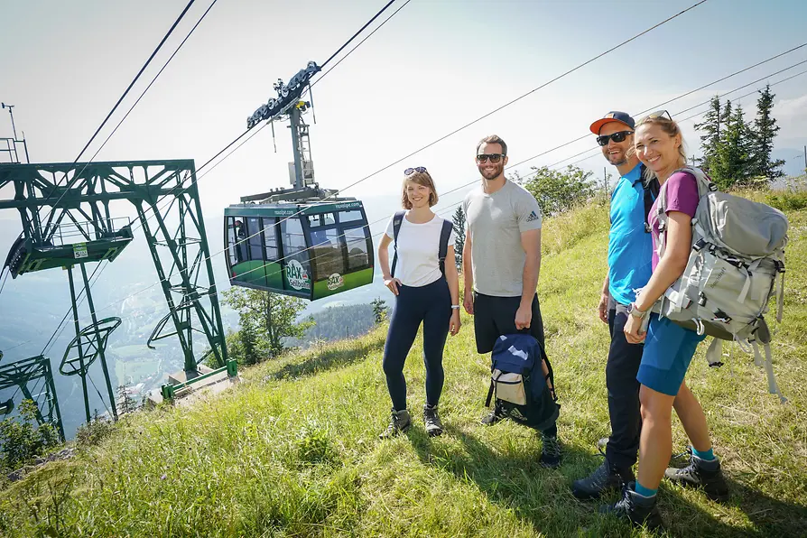 Hikers on the Rax plateau, behind them the Rax cable car