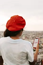 Woman holding a smartphone looks at Vienna from above