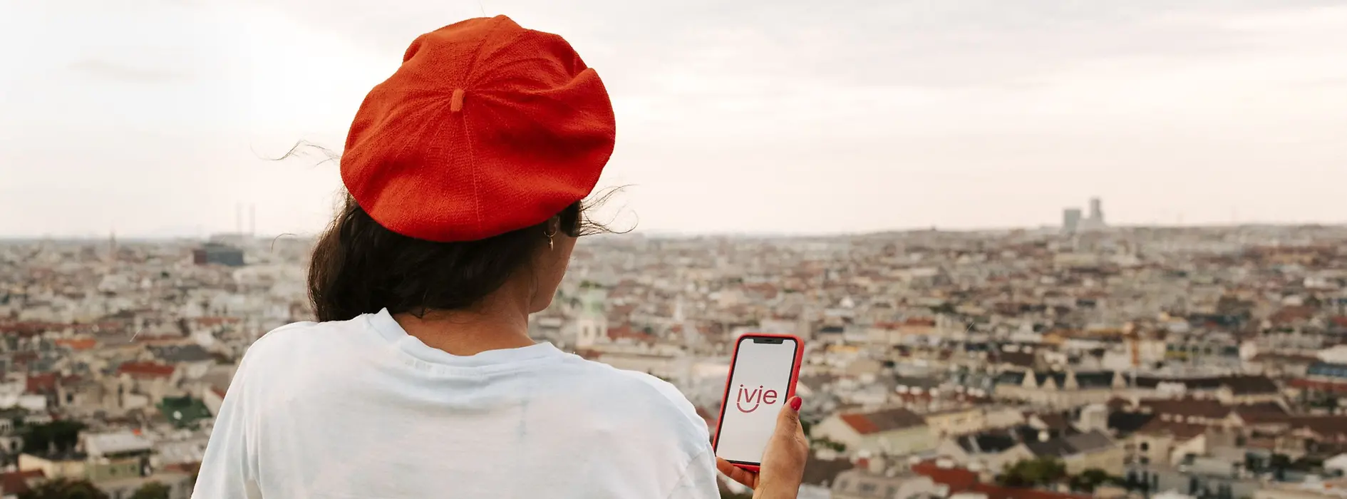 Woman holding a smartphone looks at Vienna from above