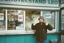 Chef Lukas Mraz in front of a sausage stand