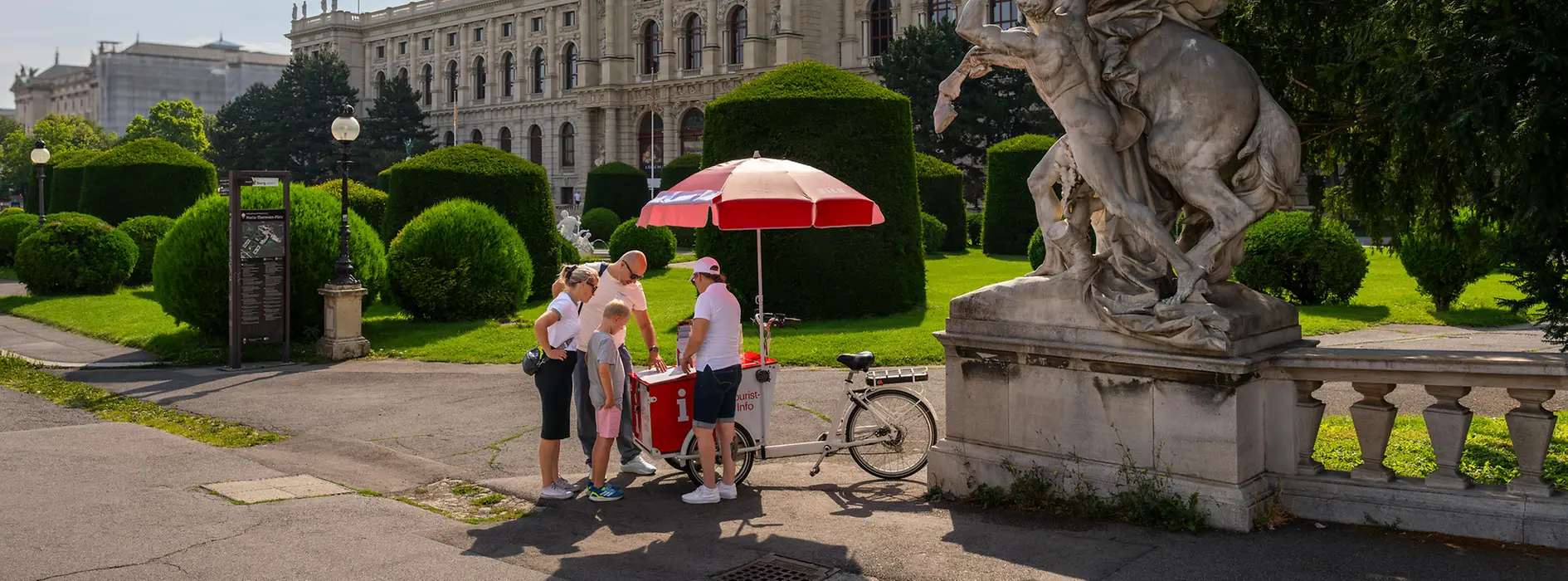 Un punto de información turística móvil con bicicletas de carga, personal y visitantes de Viena en la Maria-Theresien-Platz