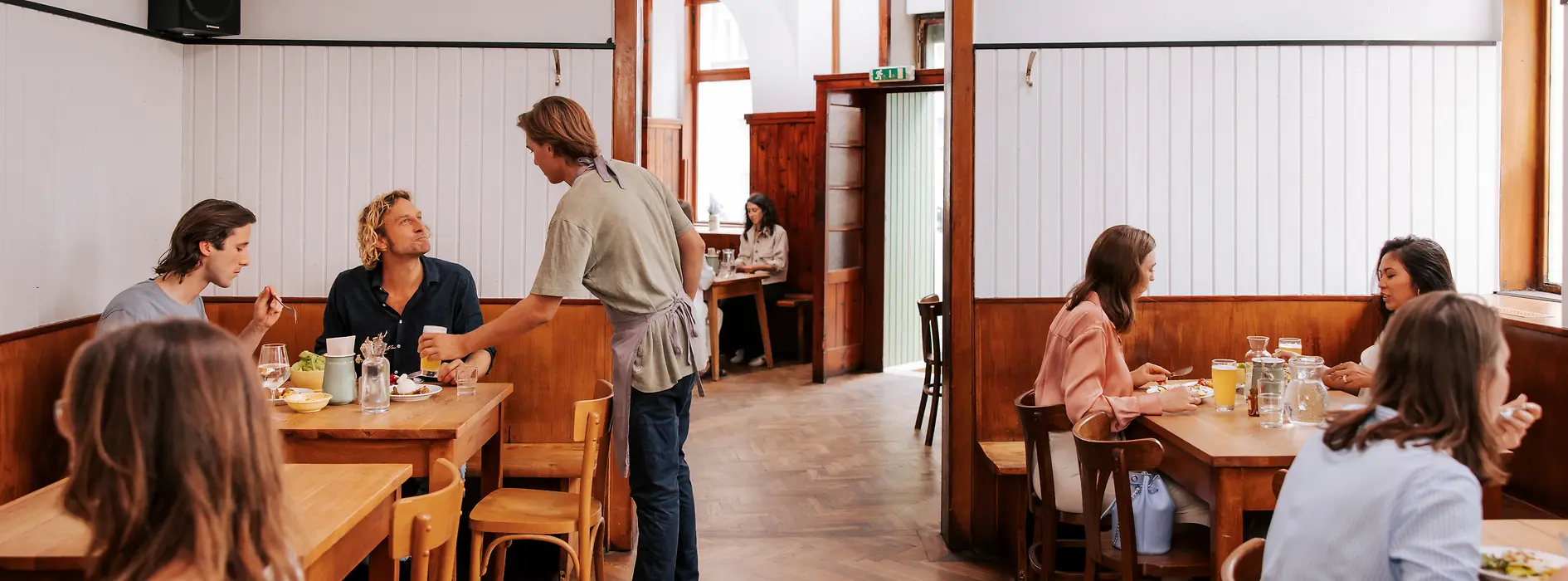 Widok wnętrza restauracji Brösl w dzielnicy Stuwerviertel, goście są obsługiwani