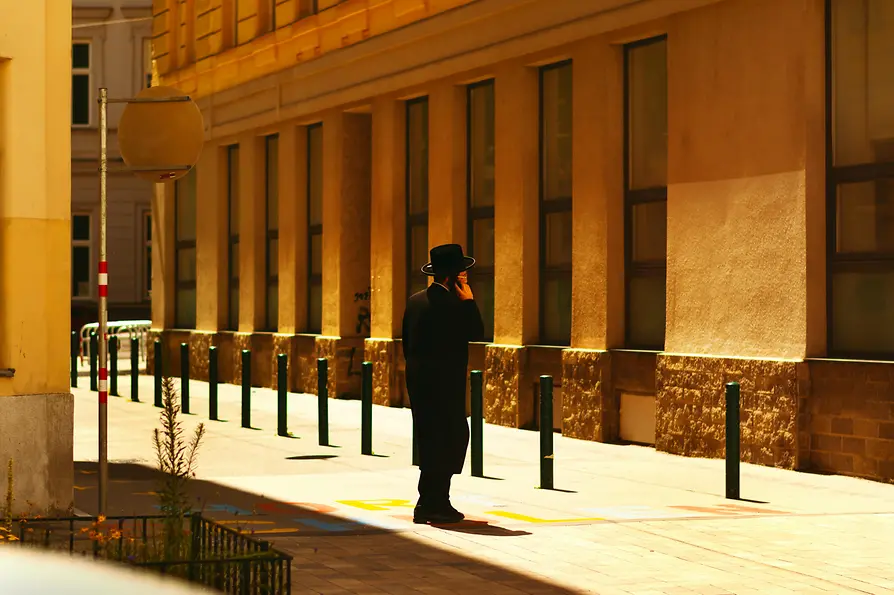 Un judío ortodoxo llamando por teléfono en una calle de Viena
