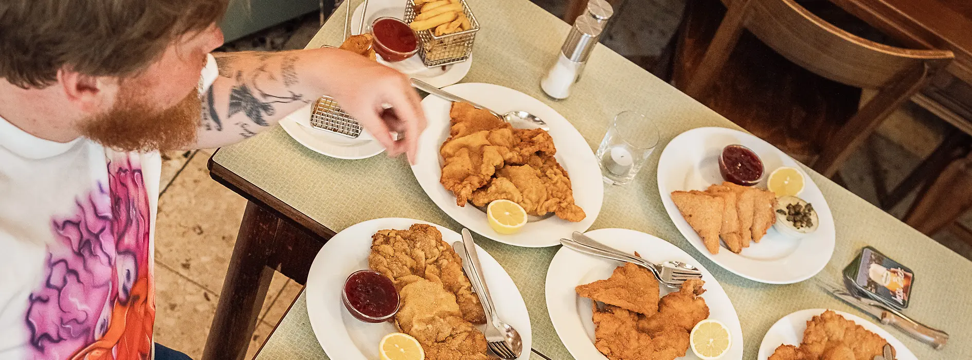 Two people at a table with numerous Wiener schnitzels