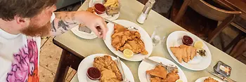 Dos personas en una mesa con numerosos Wiener Schnitzel