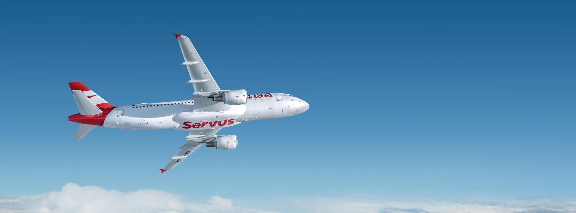 Weißes Flugzeug mit roter Aufschrift "Servus" von Austrian Airlines, das über den Wolken fliegt