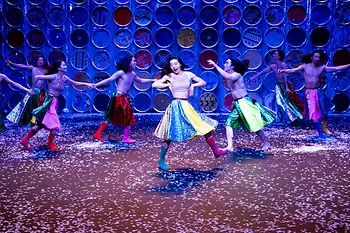 Koreanische Tänzer:innen wirbeln in bunten Röcken und Stiefeln auf der Bühne herum.