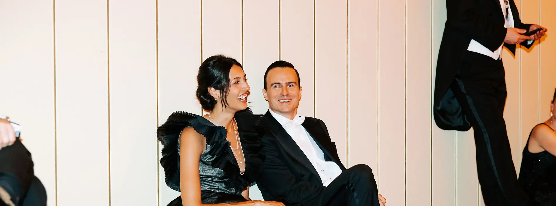 Paar in Ballkleidung sitzt am Boden und erholt sich vom Tanzen