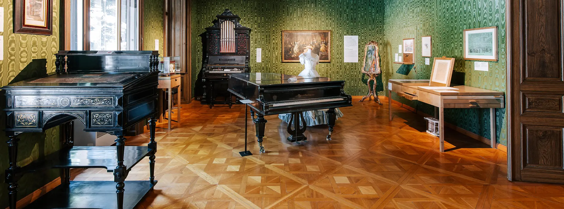 Salotto verde nell'appartamento Strauss con leggio, pianoforte e custodia per violino