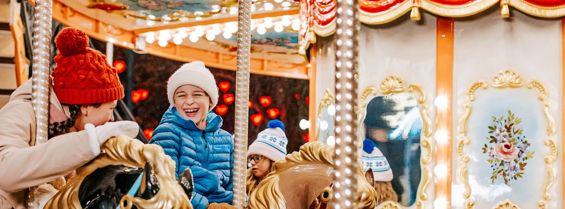 Children on a merry-go-round at the Christmas market on Rathausplatz