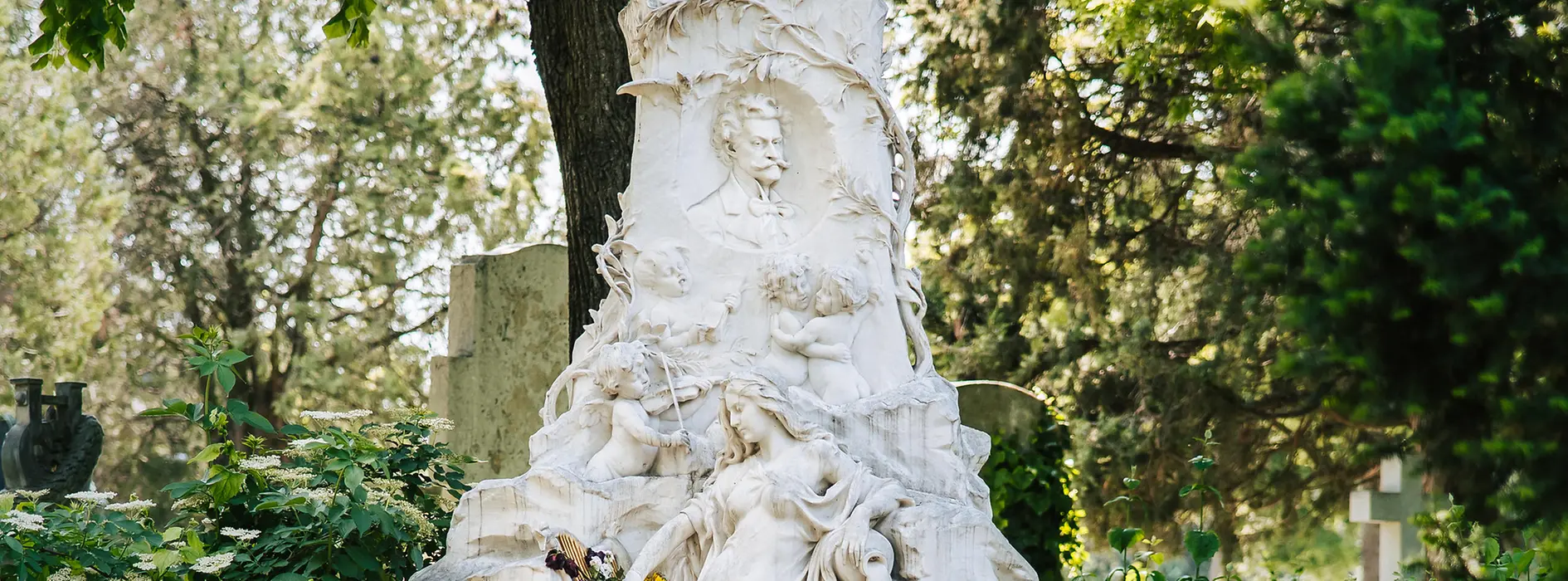 Tomba in marmo di Johann Strauss Sohn con la sua testa in rilievo, oltre a una figura femminile, un pipistrello e un angelo che suona il violino nell'imponente monumento.