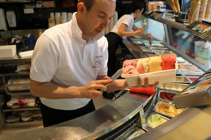 Heladería Paolo Bortolitti en la Mariahilferstraße, heladero preparando una gran porción de helado