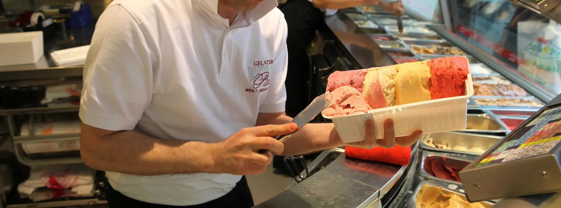 Glacier Paolo Bortolitti sur la Mariahilferstraße, un employé préparant une grosse portion de glace