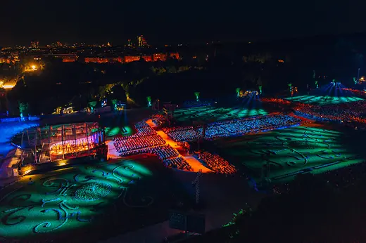 Sommernachtskonzert 2024 der Wiener Philharmoniker in Schönbrunn mit beleuchtetem Publikum und Schlosspark bei Nacht
