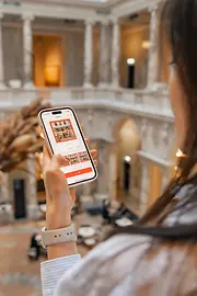 Señora de pelo oscuro mirando la pantalla de su smartphone.