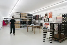 Blick ins Archiv mit Regalen, einem Tisch und einem Käfig