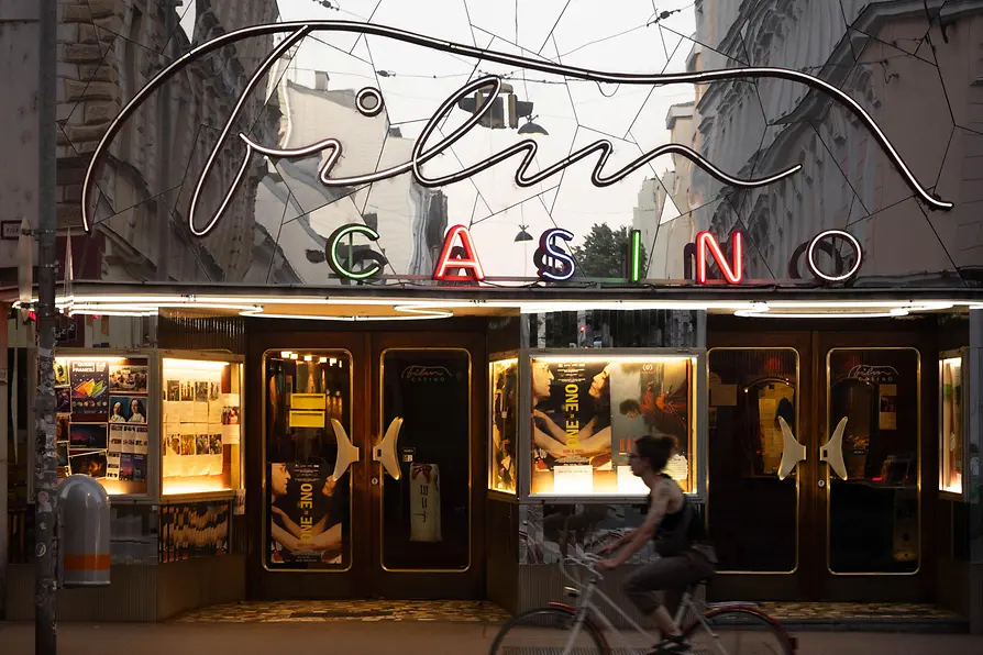 Vista serale dell'ingresso del Filmcasino a Vienna con illuminazione al neon