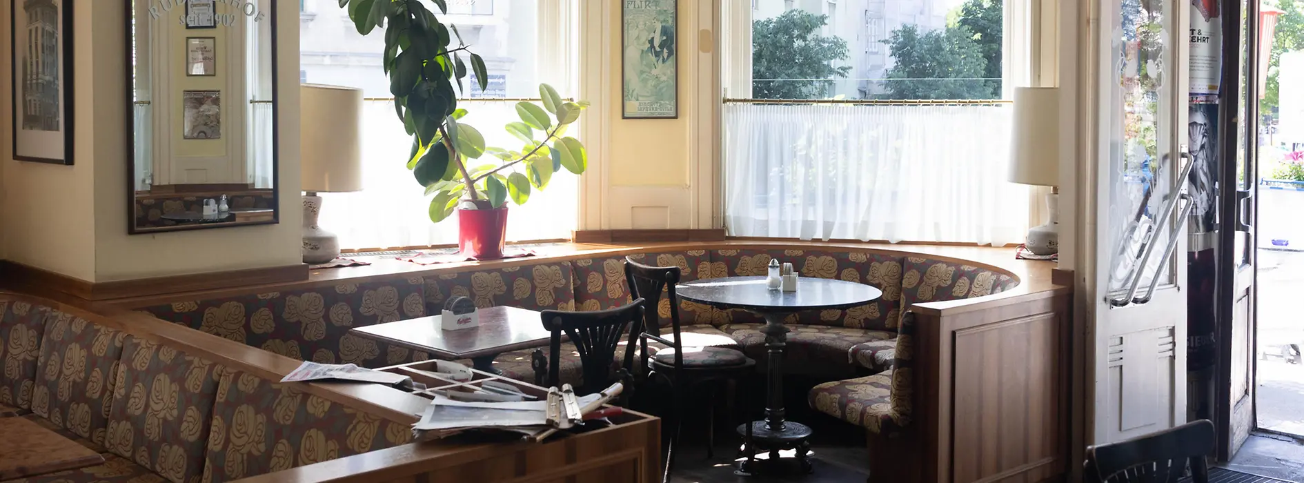 Interior del Café Rüdigerhof en Viena con asientos tipo banco y grandes ventanas