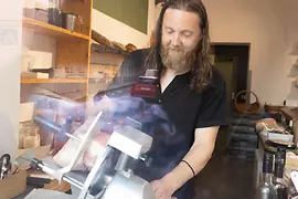Man slicing ham at the Babo & Lenz delicatessen in Vienna
