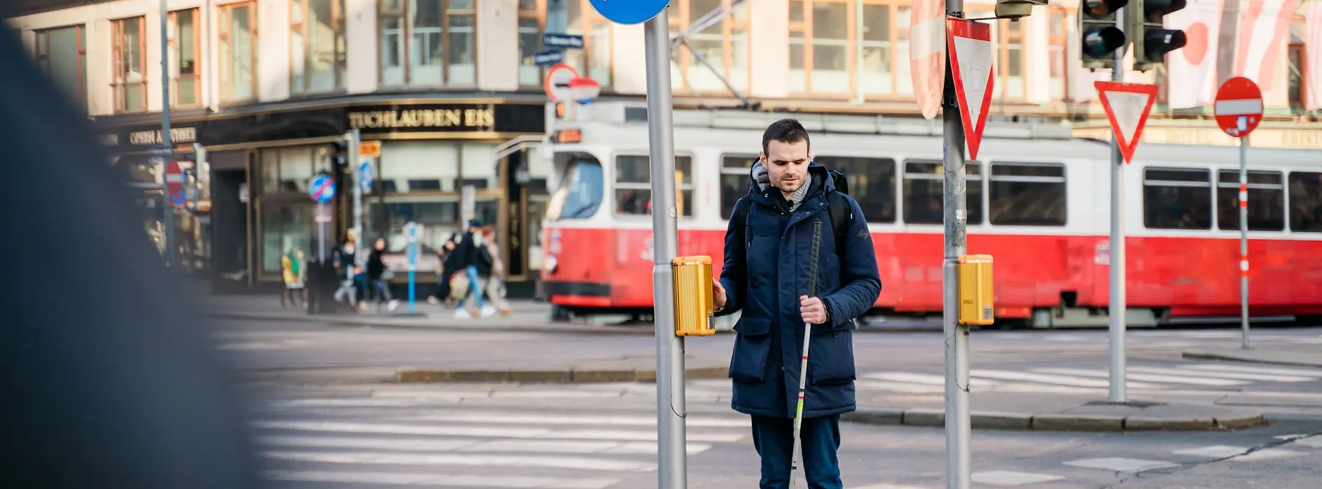 Blinde Person nutzt Akustik-Taktile-Ampel.