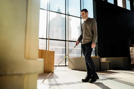 Blinde Person nutzt taktiles Bodenleitsystem.