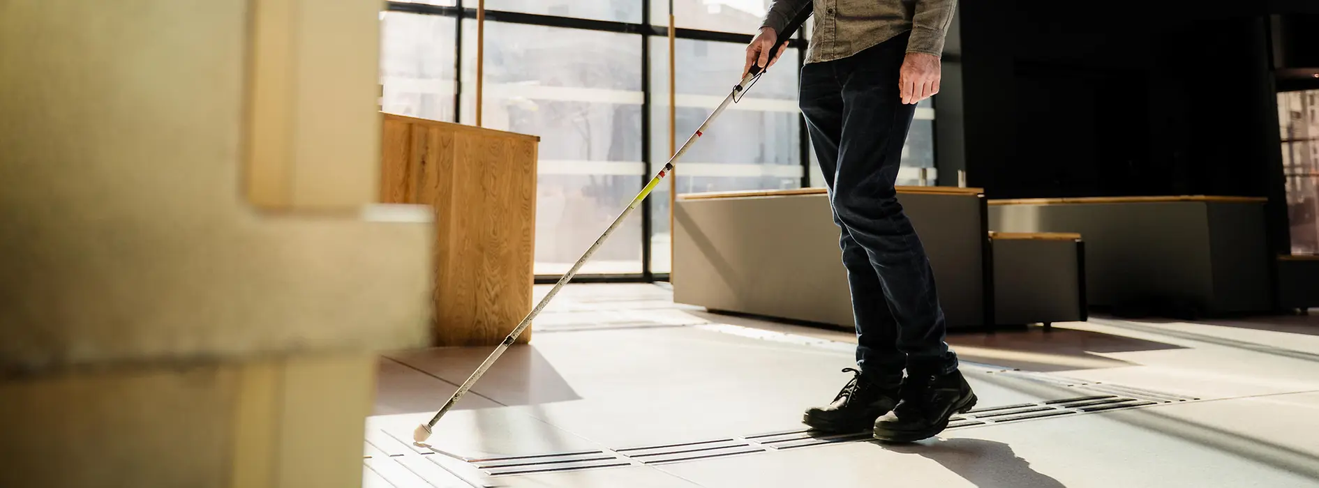 Blinde Person nutzt taktiles Bodenleitsystem.