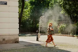 Female pedestrian with mist shower in the Piaristenviertel