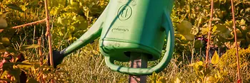 Gießkanne hängt in einem Garten