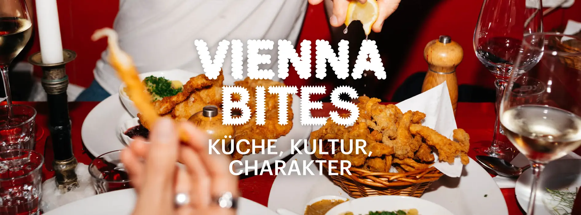 Schriftzug "Vienna Bites. Küche, Kultur, Charakter" im Hintergrund Essen auf einem Tisch